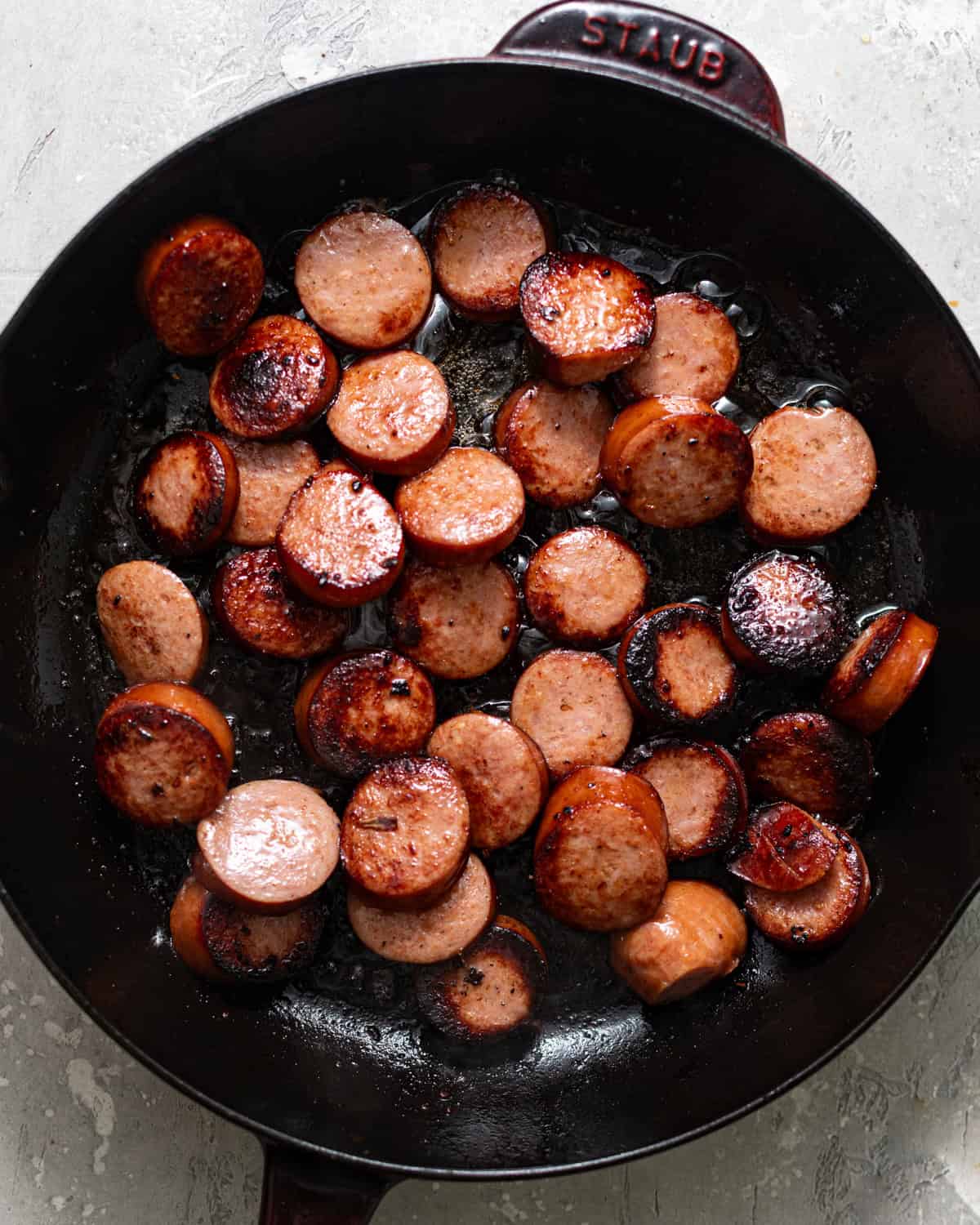 sliced sausages browned in a skillet.