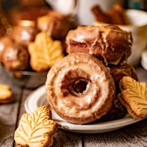maple donuts on a plate with a small maple cookie in front of it.