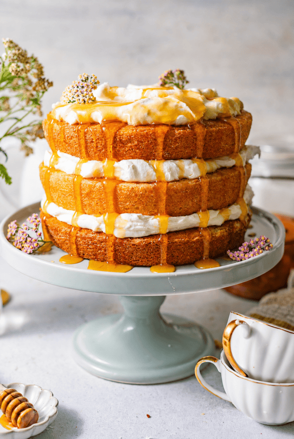 Milk and honey layer cake with whipped cream filling and golden honey drizzled generously over the top and down the sides.