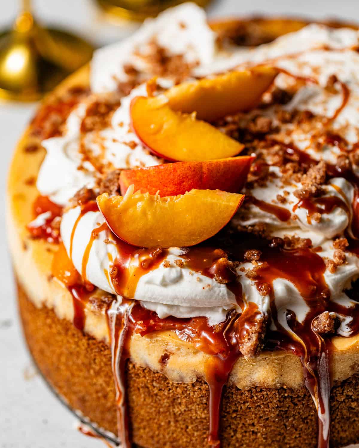 the top of the peach cobbler cheesecake showing the salted caramel sauce drizzling down.