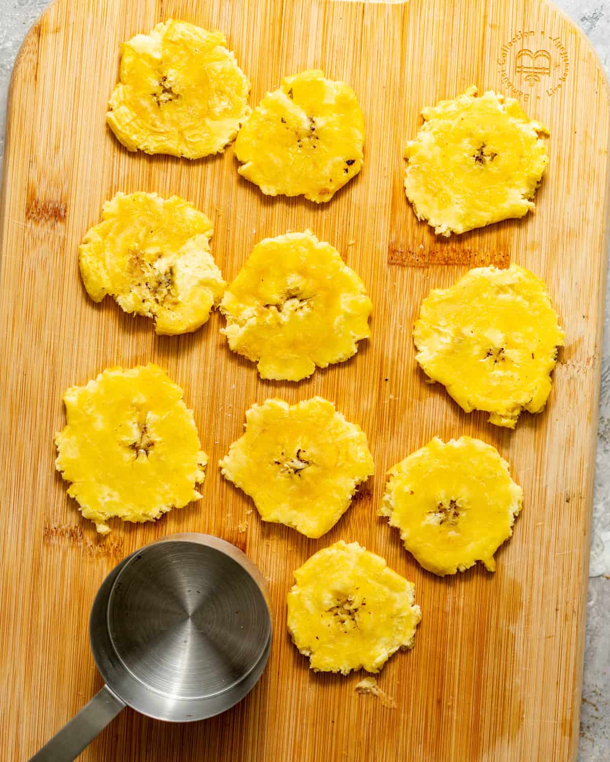 smashed plantains on a cutting board.