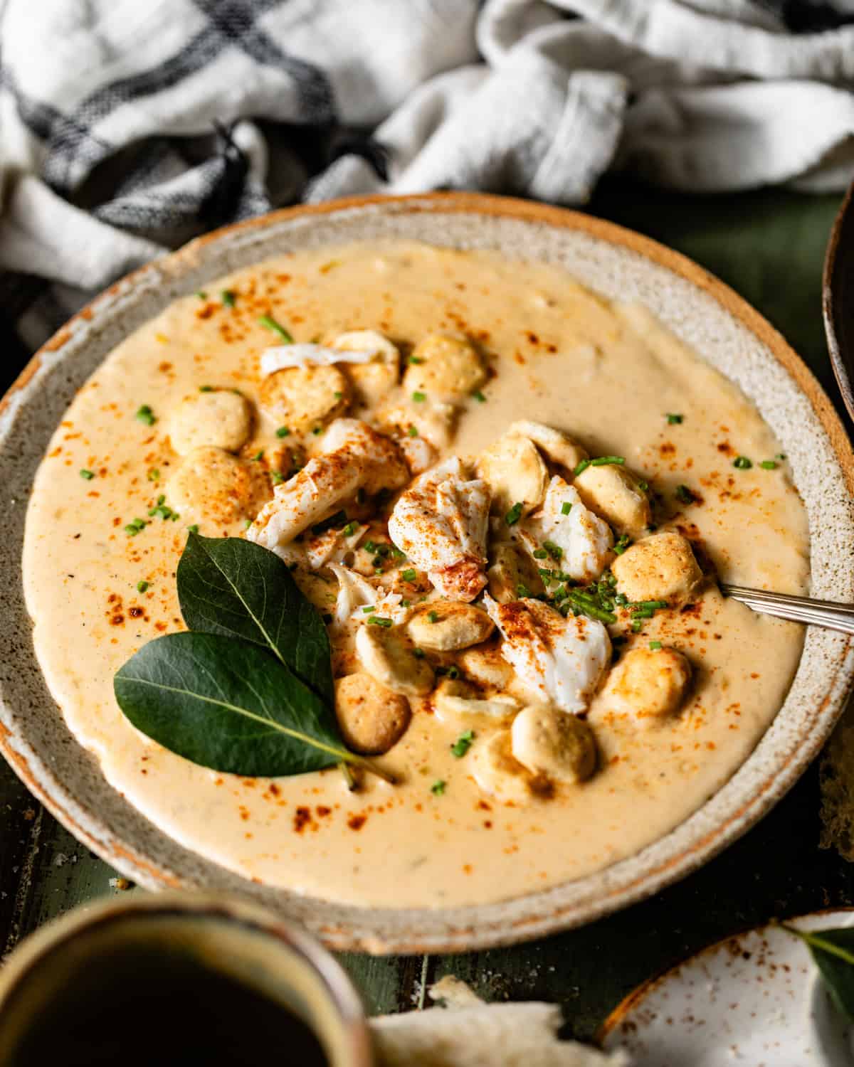 she crab soup in a bowl with a spoon garnished with crabmeat.