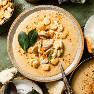 she crab soup in a bowl with a spoon topped with oyster crackers, jumbo lump crab, and a dash of old bay seasoning.