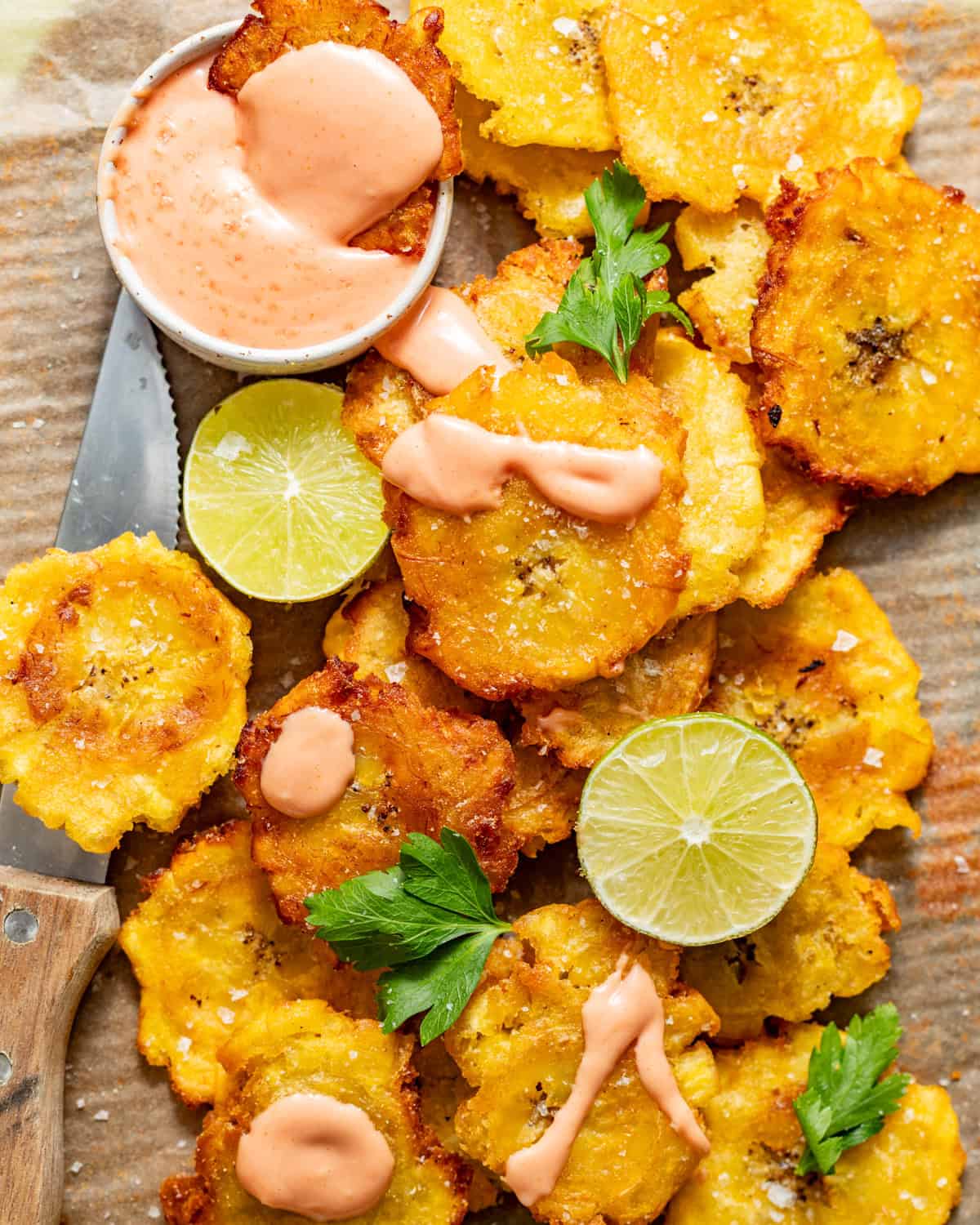 fried tostones on a plate with mayo ketchup in a small bowl. 
