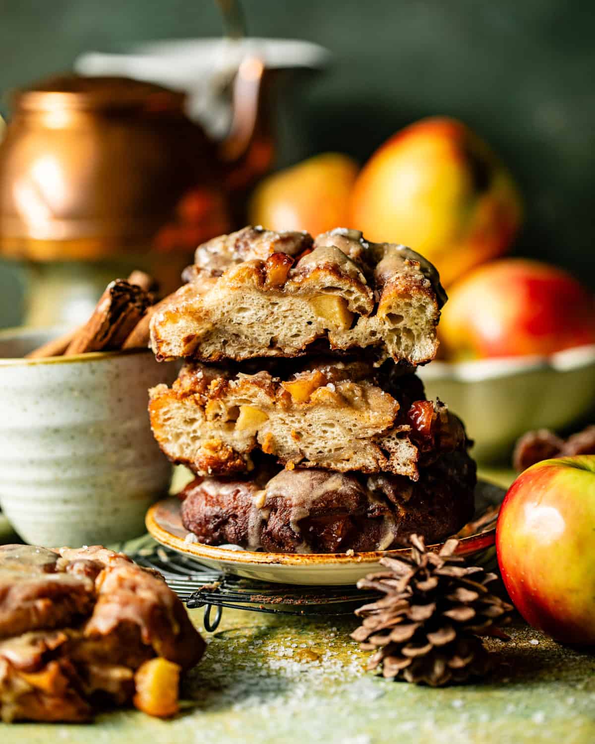 apple fritters cut in half and stacked on top of each other.