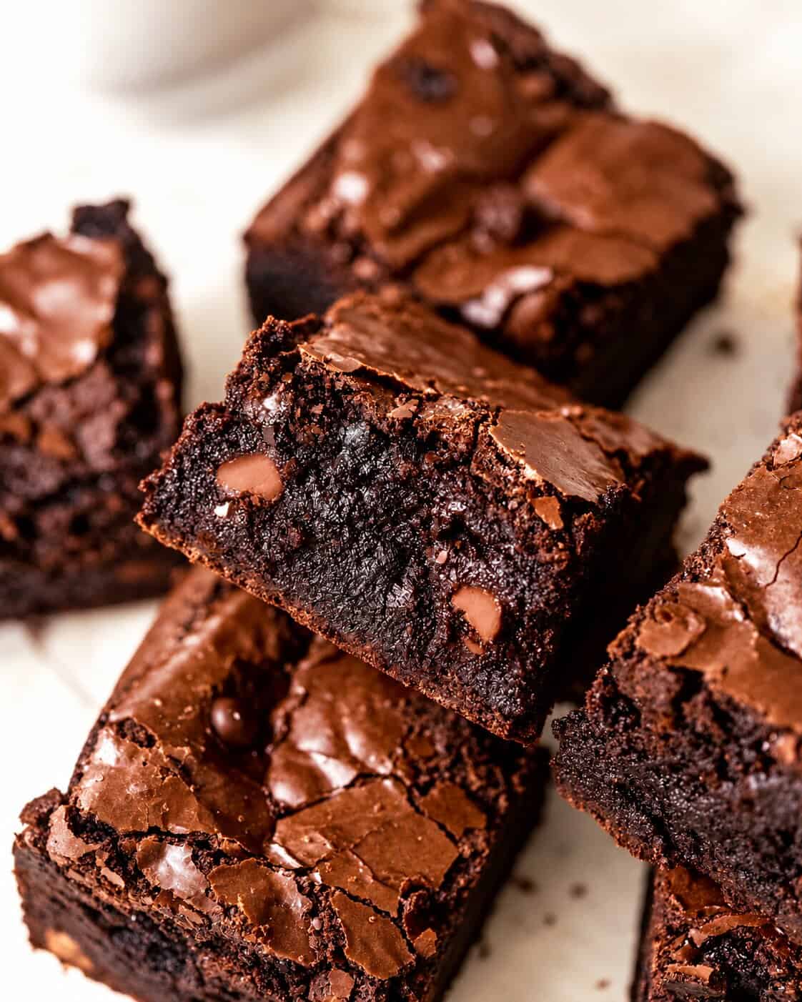 black cocoa brownies cut into squares on a white surface.