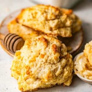 baked cornbread drop biscuits with a fluffy, tender interior and sweet corn kernels, served with homemade honey butter.