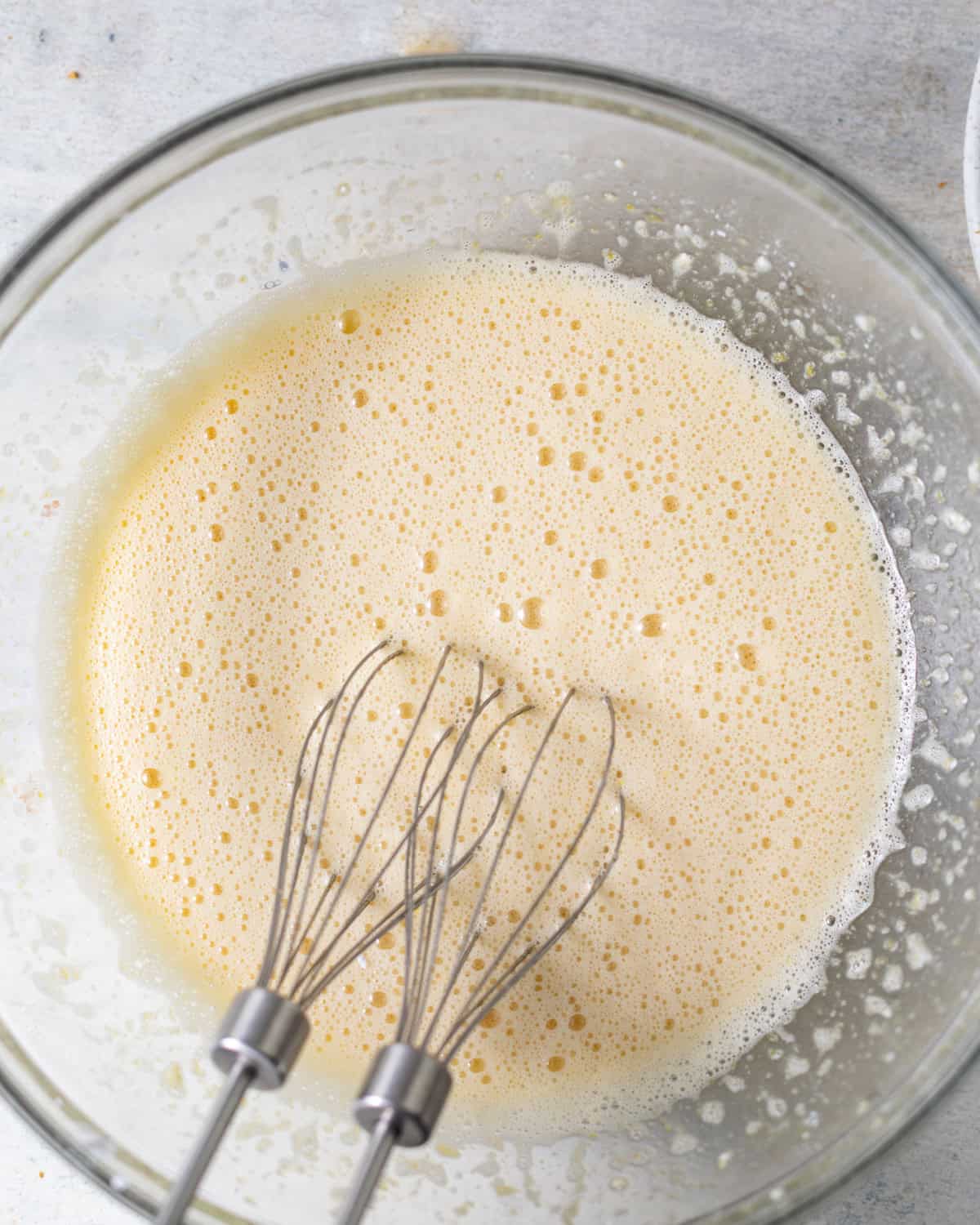 whisked eggs and powdered sugar in a bowl, mixed until foamy and pale.