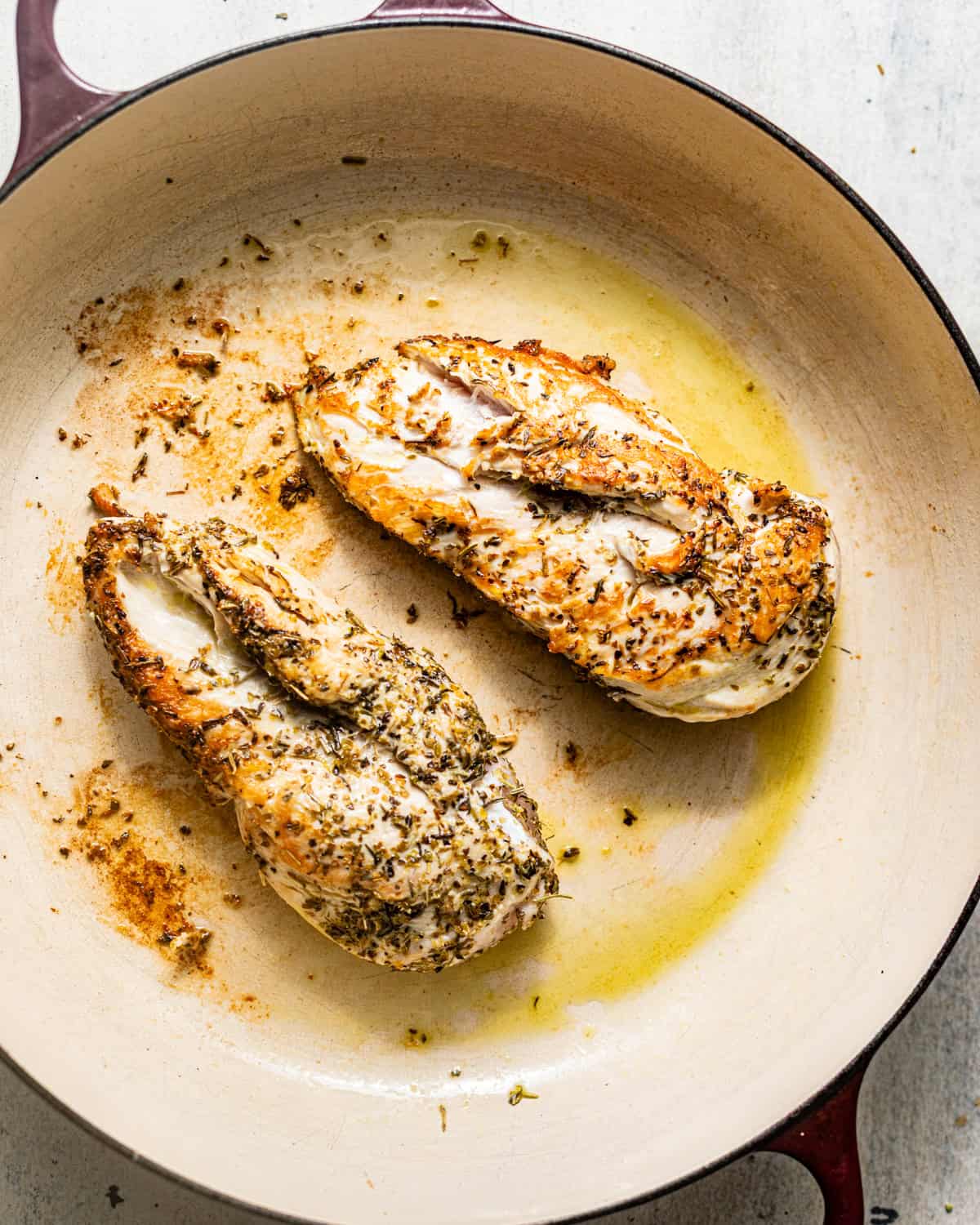 seasoned seared chicken in a pan.