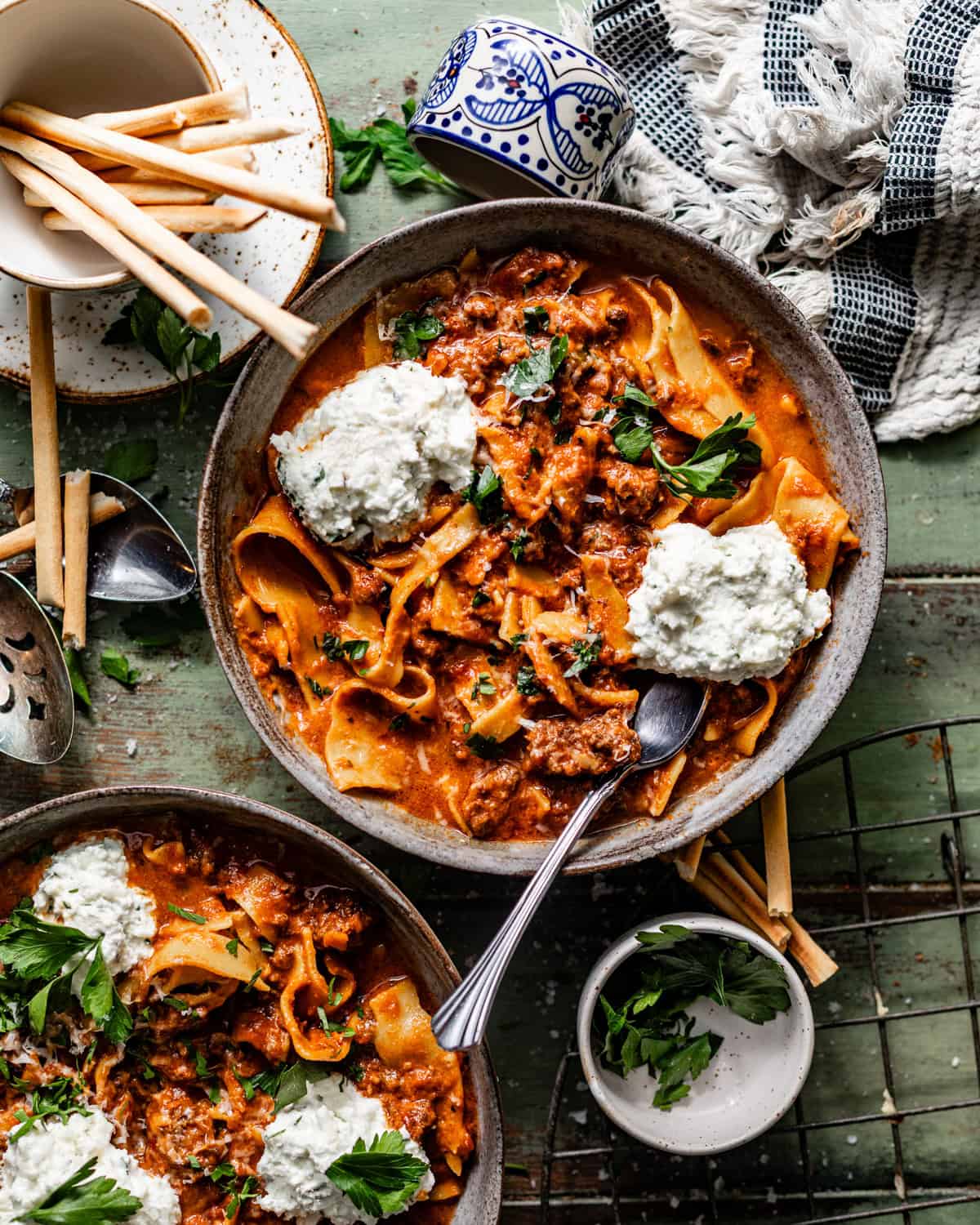slow cooker lasagna soup in a bowl topped with ricotta and fresh herbs. 