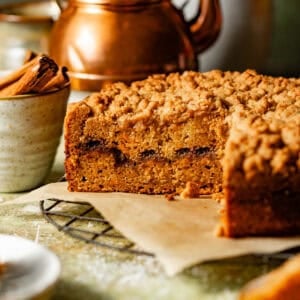 sweet potato coffee cake on a wire rack with a slice cut out to see the cinnamon swirl filling.