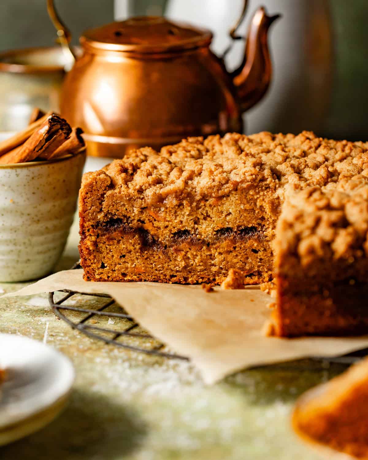 sweet potato coffee cake on a wire rack with a slice cut out to see the cinnamon swirl filling.